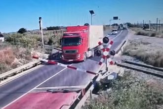 Momentul în care un șofer de TIR trece peste bariera de cale ferată, în Constanța. Circulaţia feroviară a fost afectată